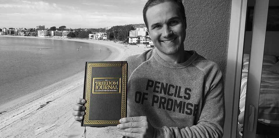 foto de John Lee Dumas con una copia de su Freedom Journal